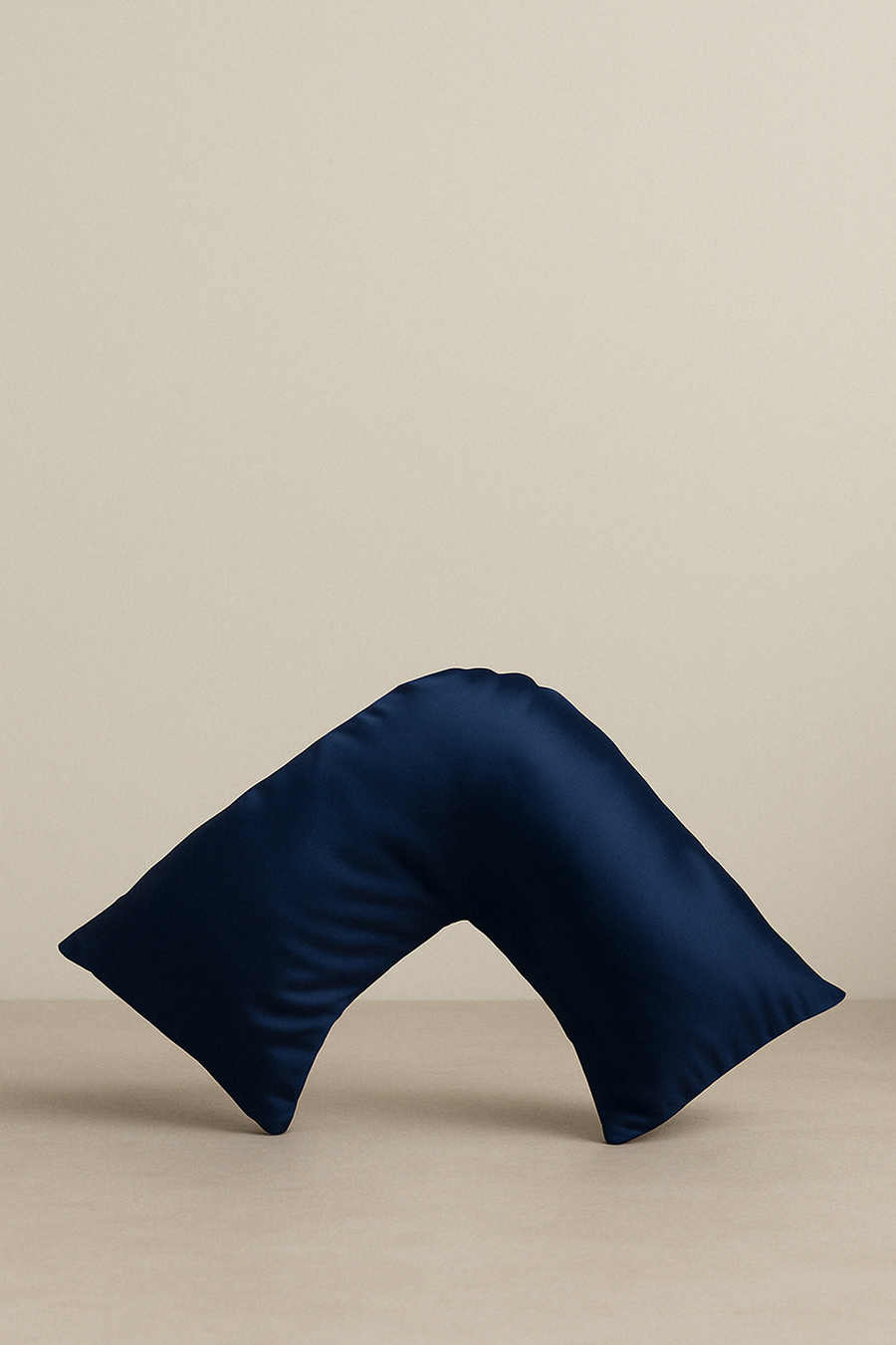 A navy blue silk pillowcase designed for V-shaped pillows, displayed against a neutral background.